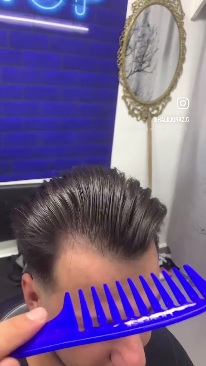 A finished men's haircut — clean fade and volume on top